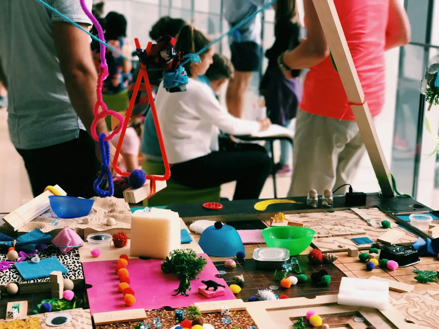 Personas colaborando en proyectos de manualidades con materiales coloridos.